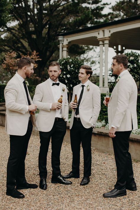 madeleine kurtis | to the aisle australia Black Suit Cream Tie, Black Suit With Neutral Tie, Men’s Wedding Looks, Tan Suit Black Tie, Tux Ideas For Wedding, Cream Groomsmen Attire, Groom Outfit Ideas, Fern Photography, Suits Groomsmen