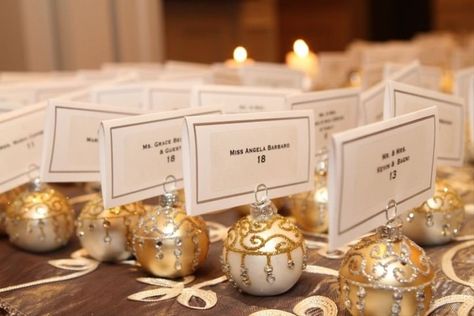 25 Awesome Christmas Wedding Ideas - Want to make your wedding a festive affair for the holidays? Here are a few holly jolly Christmas wedding ideas worth considering. table names escort seating ornaments gold {A Personal Touch} Ornament Table Numbers, Ornament Place Settings, Ornament Place Card Holder, Wedding Favors For Guests Christmas, Holiday Wedding Seating Chart, Christmas Ornament Table Number, Christmas Table Plan Wedding, Christmas Wedding Activities, Wedding Christmas Ornament Favor