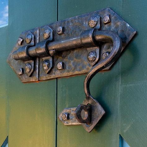 Our hand-forged Guardian door latch is the perfect addition to any home. Expertly crafted by our master blacksmith in Washington, USA, each piece is unique and made with the utmost care and attention to detail. The sturdy solid iron construction is durable and built to last, while the beautiful hand-forged design adds a touch of rustic elegance to your door. Upgrade your home's security and style with this one-of-a-kind door latch. Product Specifications Length of entire unit: 12 10/16"Width of Barn Door Installation, Metal Building Designs, Door Knobs And Knockers, Gate Latch, Barn Door Designs, Blacksmith Projects, Antique Doors, Doors And Hardware, Forging Metal