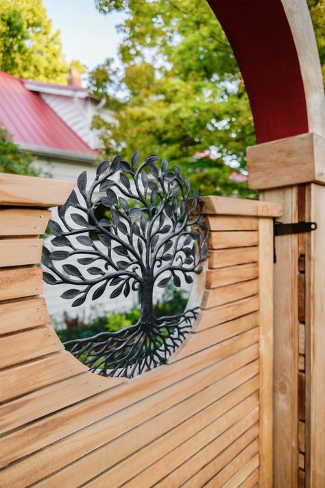 A tree of life emblem accents a custom wood gate. #treeoflife #fence #gate #customfence #landscapedesign #boardandvellum Circle Gate Design, Circle Gate, Tree Of Life Gate, Circle Garden Gate, Gate Within A Gate, Garden Gate Ideas, Gate Wood And Metal, Patio Gates, Laser Cut Metal Gate Tree