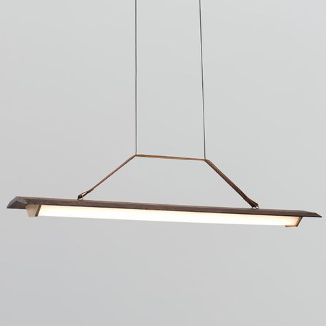 The Penna Linear Pendant offers an elegant design that balances utility and sophisticated beauty, featuring a slightly curving Walnut wood rectangular beam with a half hexagonal Frosted polymer diffuser below with Brass endcaps, suspended with a leather strap and aircraft cable. Available in two sizes with 2700K or 3500K color temperature options. Dimmable with compatible TRIAC, ELV, or 0-10V dimmers. Linear Pendant Lighting, Modern Led Lighting, Cluster Pendant Lighting, Linear Pendant Light, Industrial Wood, Led Light Fixtures, Long Lights, Pendant Light Design, Linear Pendant