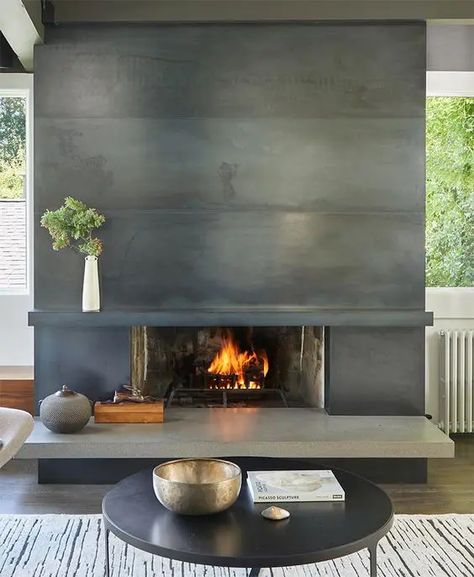 a modern living room with a metal clad fireplace, a coffee table and some decor is an airy space Metal Fireplace Surround, Modern Fireplace Tiles, Midcentury Modern Fireplace, Concrete Hearth, Modern Mantle, Hearth Ideas, Mid Century Modern Fireplace, Fireplace Walls, Modern Fireplace Mantels