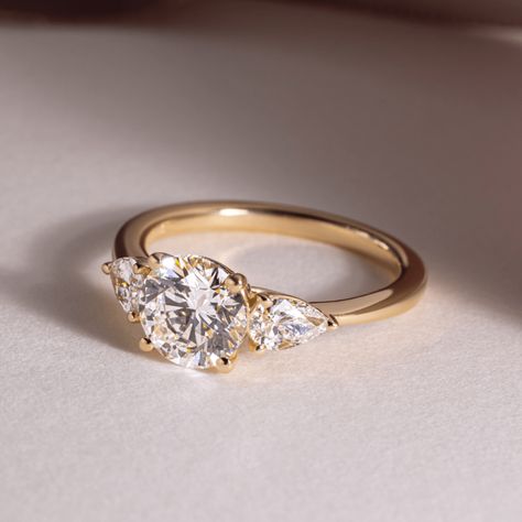 Exceptional lab-grown diamond ring showcasing a trilogy of sparkling round brilliants, totaling 1.25 carats, set in lustrous 14K/18K yellow/white/rose gold. This exquisite three-stone ring symbolizes the past, present, and future of your love, making it a perfect engagement or anniversary gift. 𝐅𝐞𝐚𝐭𝐮𝐫𝐞𝐬:• 𝐌𝐚𝐝𝐞 𝐭𝐨 𝐎𝐫𝐝𝐞𝐫• 𝐌𝐞𝐭𝐚𝐥: 𝟏𝟒𝐊 𝐆𝐨𝐥𝐝 | 𝟏𝟖𝐊 𝐆𝐨𝐥𝐝 | 𝟗𝟓𝟎 𝐏𝐥𝐚𝐭𝐢𝐧𝐮𝐦• 𝐁𝐚𝐧𝐝 𝐂𝐨𝐥𝐨𝐫𝐬: Rose Gold, Yellow Gold & White Gold• 𝐁𝐚𝐧𝐝 𝐖𝐢𝐝𝐭𝐡: 1.80 MM• 𝐁𝐚𝐧𝐝 𝐓𝐡𝐢𝐜𝐤𝐧𝐞𝐬𝐬: 1.60 MM 𝐂𝐞𝐧𝐭𝐞𝐫 𝐬𝐭𝐨𝐧𝐞:• 𝐒𝐭𝐨𝐧𝐞 - Lab Grown Diamond• 𝐒𝐡𝐚𝐩𝐞 - Brilliant Cut Round• 𝐂𝐚𝐫𝐚𝐭 𝐖𝐞𝐢𝐠𝐡𝐭 - 1.25 Carats• 𝐏𝐢𝐞𝐜𝐞𝐬 - 1 Piece• 𝐂𝐨𝐥𝐨𝐫 - F+• 𝐂𝐥𝐚𝐫𝐢𝐭𝐲 - VS1+• 𝐂𝐞𝐫𝐭𝐢𝐟𝐢𝐜𝐚𝐭𝐞 - 𝐈𝐆𝐈 | 𝐆𝐈𝐀 𝐒𝐢𝐝𝐞 𝐬𝐭𝐨𝐧𝐞𝐬:• Three Stone Engagement Rings Gold, 3 Diamond Engagement Rings, Three Diamond Engagement Ring, Past Present Future Ring, Gold Band Engagement Rings, Pretty Engagement Rings, Trilogy Engagement Ring, Wedding Rings Round, Yellow Engagement Rings