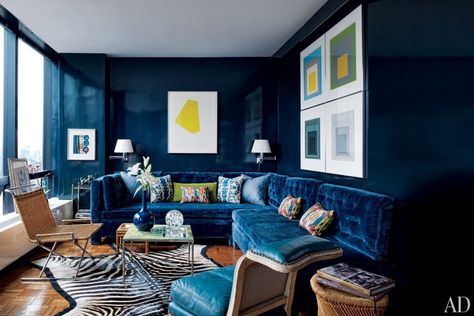 Inside a glass tower overlooking the Manhattan skyline, Todd Alexander Romano created a high-impact design for his 600-square-foot studio. Inspired by the bold color choices of legendary decorator Billy Baldwin, the designer lacquered the walls and upholstered the custom-made sofa in midnight-blue | archdigest.com Zebra Rugs, Lacquered Walls, Navy Blue Living Room, Blue Velvet Sofa, Blue Couches, Dark Walls, Room Paint Colors, Blue Sofa, Blue Living Room