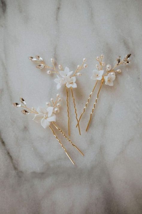 Delicate clay flowers, freshwater pearls and sparkling crystals adorn this hair pin trio. These pins can be styled on their own or in multiples to create a stunning boho-inspired bridal headpiece.  Available in silver and gold. Bridal Hairpieces, Boho Bridal Headpiece, Bridal Hairpins, Flower Hair Pins Wedding, Boho Hair Pins, Pearl Hair Pin Wedding, Wedding Aesthetics, Bridal Hairpiece, Floral Hair Pins