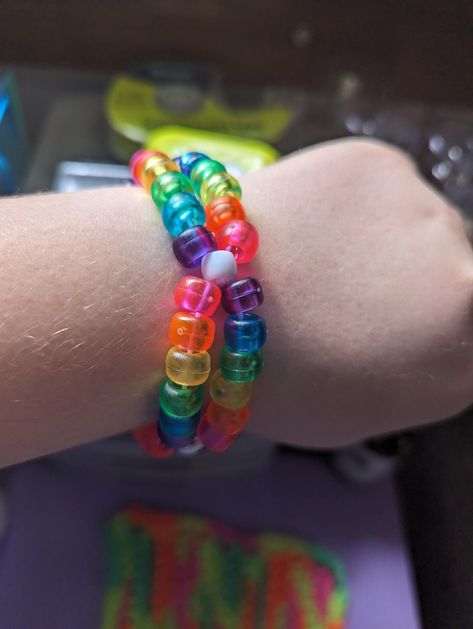 Handmade transparent rainbow kandi double, made with stretchy string. Safety Pin Jewelry Patterns, School Chromebook, Rainbow Kandi, Rave Bae, Bracelets Kandi, Aesthetic Crafts, Loom Band Patterns, Current Aesthetic, Kandi Inspo