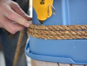 Cover the entire exterior surface of the plastic bin by wrapping the jute or sisal rope around it, then securing it in place with hot glue. Allow each layer to slightly overlap the other. This will ensure proper coverage without exposing the plastic. Diy Large Storage Basket, Plastic Tote Makeover, Covering Plastic Storage Bins, Plastic Storage Bin Makeover, Cardboard Hacks, Plastic Drawer Makeover, Milk Crate Storage, Toy Storage Bin, Cleaning Fast