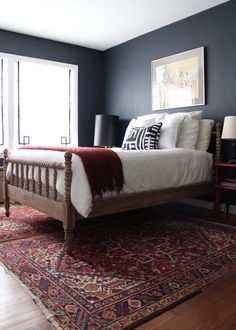 Persian rugs under bed gives this room the wow factor - dark wall colour like BM Hale Navy