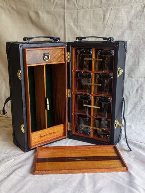 This meticulously crafted mobile bar is handmade using hardwood and vegetable tanned leather.  A hardwood box is wrapped with hand dyed leather and inset with mahogany and felt. It comes with 8 whiskey glasses and space for 2 bottles. A serving tray nests inside and all pieces are locked in place with solid brass toggles. A small drawer holds ice tongs and other various items.  At home either out doors or in the house this field Bar is the epitome of rugged refinement.  Made to order. Please all Field Desk, Home Lounge Room Bar, Luxury Wooden Boxes, Japanese School Bag, Concealment Furniture, Campaign Furniture, Ice Tongs, Portable Bar, Dining Ware