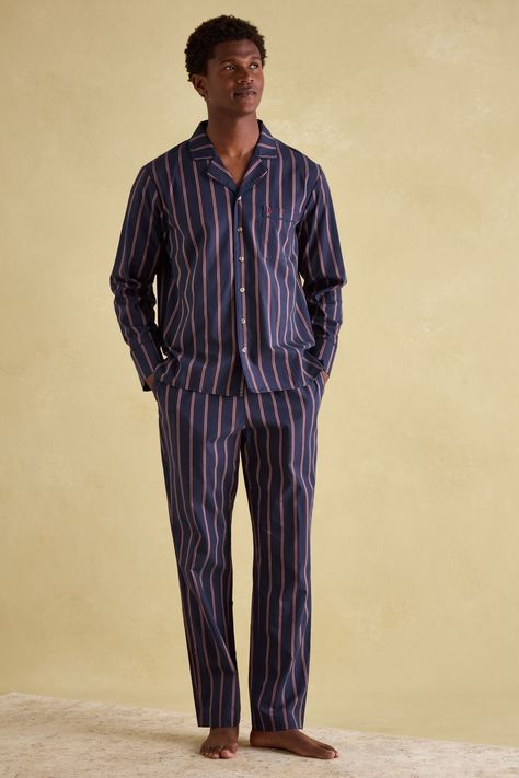 Designed for downtime, this set of men's pyjamas will have him kicking back in style and comfort. They're crafted from soft 100% cotton and feature a classic pinstripe design for a truly gentrified look. The button down shirt has a lapel collar, a single patch pocket to the chest and piped trims, while the matching bottoms have an elasticated waist with drawstring ties and a branded tab to the front. Side pockets complete the set and add to its laid-back appeal. 100% cotton. Pyjama set. Button d Men’s Loungewear, Panto Costumes, Pyjamas Aesthetic, Pyjamas Men, Striped Pyjama, Pinstriping Designs, Cute Pajama Sets, Sequin Outfit, Revere Collar