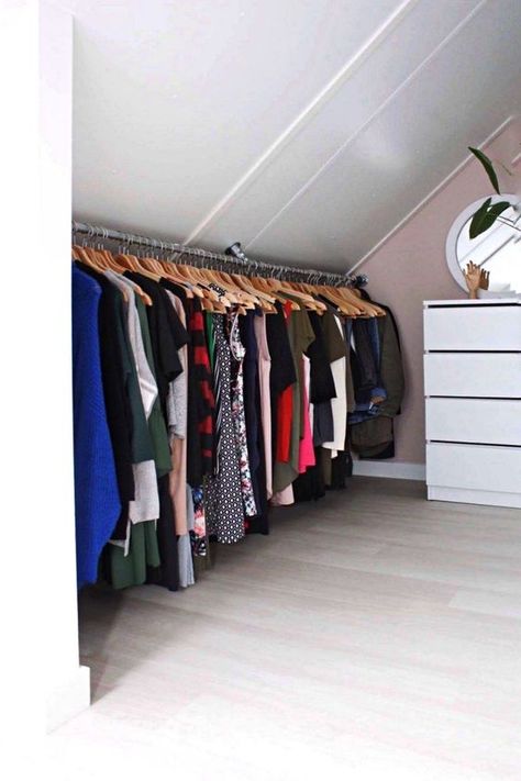 a cool attic closet wiht a pink accent wall, a white dresser, a rail with clothes is a very smart idea for a small home with an attic Slanted Ceiling Closet, Attic Closet Ideas, Loft Closet, Small Attic Room, Pink Accent Walls, Attic Bedroom Storage, Clothes Shelves, Attic Closet, Built In Dresser