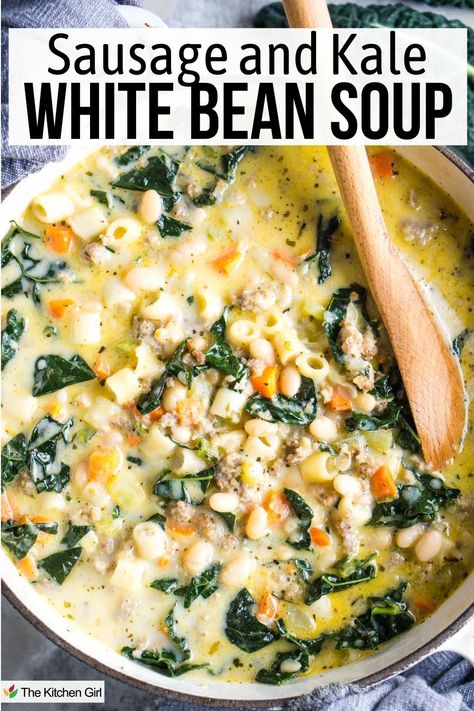 A bowl of white bean soup with sausage, kale, and diced vegetables. The soup is creamy, with visible beans, carrots, and kale. A wooden spoon rests in the bowl. Text at the top reads "Sausage and Kale White Bean Soup". Sausage Kale White Bean Soup Instant Pot, White Bean Sausage And Kale Soup, Creamy White Bean And Kale Soup, White Bean Kale Soup Crockpot, Kale Soup Recipes Sausage, Sausage White Bean Kale Soup, Creamy Kale Soup, Fall Crock Pot Soup Recipes, White Bean Sausage Kale Soup