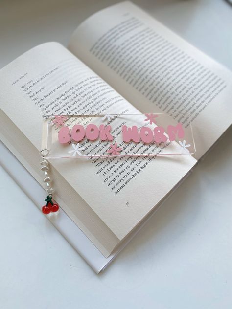 Bookworm Bookmark. Acrylic Bookmark with vinyl decal and bead charm Made using strong & durable 2mm acrylic  bookmark - 3.2cm/1.26inch x 12cm/4.72inch, 3.0mm thickness Pink wording with pearl beading and a cherry charm Note - The designs are HANDMADE AND FREEHAND. The product you receive might vary slightly from the picture. Cricut Keyrings, Acrylic Bookmarks Cricut, Booktok Bookmarks, Vinyl Bookmarks, Acrylic Bookmark Ideas, Cricut Bookmarks, Bookworm Bookmark, Bookmark Acrylic, Acrylic Bookmarks