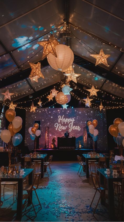 Festive New Year's party setup with hanging star lanterns, balloons, and a "Happy New Year" sign on stage. Outdoor New Years Decor, Cozy Nye Party, Cheap New Years Eve Decorations, New Years Eve Centerpiece Ideas, New Year Decorations 2025, New Years Eve Party Ideas Decorations Table Settings, New Year Eve Table Decorations, New Years Eve Tree, New Year’s Eve Aesthetic