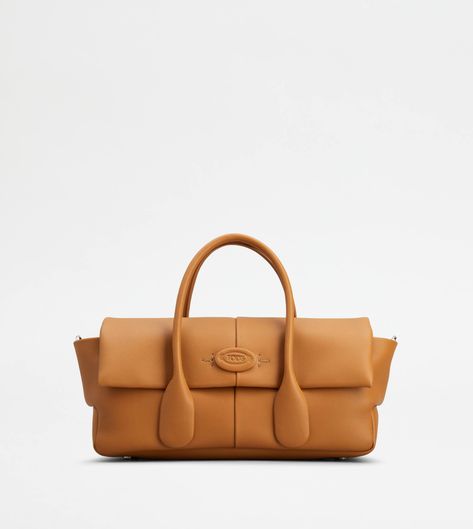 The timeless elegance of the Di Bag style is declined in a refined flap version. Crafted in fine natural grain calfskin leather, it features the distinctive tubular handles and the Tod's logo on the front, enriched by an embossed oval and side T-stitching. Closed with flap and magnet, it comes with an adjustable and removable shoulder strap, for a versatile wearability, with an ever-feminine allure. Tan Leather Handbags, Brown Leather Handbags, Leather Roll, Mini Handbags, Flap Bag, Bago, Lanvin, Leather Handbag, Leather Top