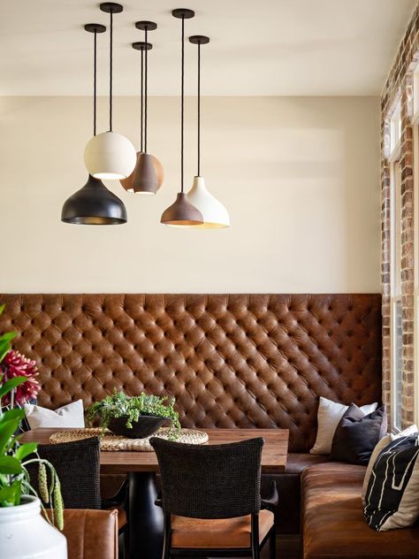 This dining room is the perfect mesh of rustic and modern. The rustic comes through with leather and brick, while a whimsical light source adds in a modern flare! + Leather Bench + Dining Room Design + Modern Light + Brick Wall + Lobby Dining Seating + Rustic Modern Dining Room + Tall Bench Seat | Design by Lori Clarke Design Masculine Dining Room, Built In Bench Seating, Banquette Seating In Kitchen, Dining Room Bench Seating, Banquet Seating, Kitchen Banquette, Booth Seating, Dining Room Seating, Banquette Seating