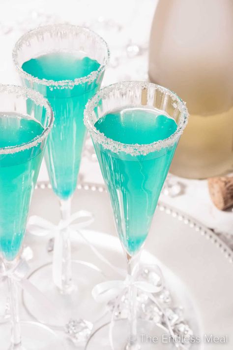 This ultra-glam Tiffany mimosa is made with sparkling wine and blue curacao to get that perfect little blue box shade. This champagne cocktail is an excellent choice for a bachelorette, a New Year celebration, a gender reveal party, or just a fun and fancy dinner party! #theendlessmeal #tiffanymimosa #mimosa #tiffanycocktail #bluemimosa #bluecuracao Pomegranate Sangria, Strawberry Mimosa, Cider Mimosas, Wine Ingredients, Apple Cider Mimosa, Mimosa Cocktail, Honey Simple Syrup, Mimosa Recipe, Fancy Dinner Party