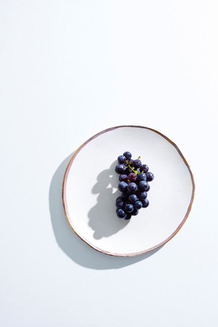 Concord grapes on the vine, on white ceramic plate on white surface Aesthetic Medicine, Photoshoot Photography, Fruits Photos, Airy Photography, Minimal Photography, Fruit Photography, Minimalist Photography, Plate Design, Ceramic Plates