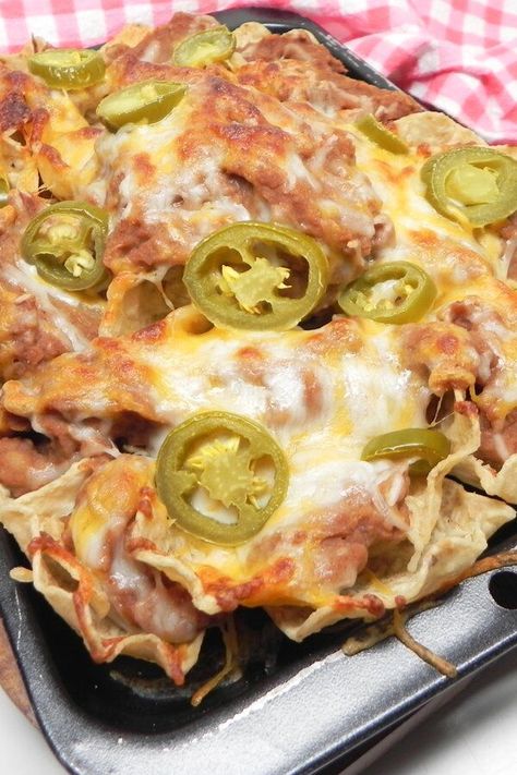 Easy Nachos with Refried Beans | "You can't go wrong with beans cheese and jalapenos. I've been making these since I was a kid and I never get tired of them." #footballrecipes #gamedayrecipes #tailgatingrecipes #superbowlrecipes #superbowlparty #superbowlpartyideas Nachos Refried Beans, Refried Bean Nachos, Bean And Cheese Nachos, Nachos With Refried Beans, Meatless Nachos, Bean Nachos Recipe, Classic Meals, Mexican Casseroles, Nacho Recipes