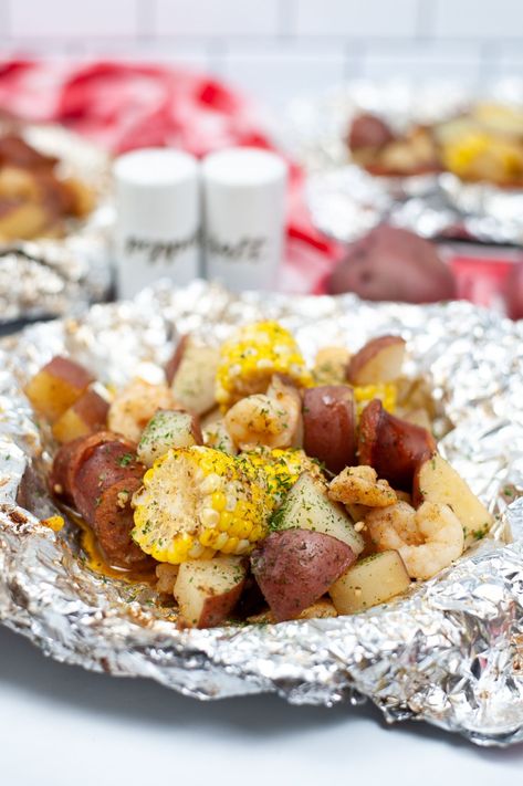 These Low Country Boil Foil Packets are a simplified version of the classic Southern dish, cooked all in one packet, making cleanup a breeze. #lowcountryboil #foilpackets #southerndish #dinner #recipe Low Country Boil Foil Packets, Seafood Sausage, Shrimp Boil Foil Packs, Easy Campfire Meals, Shrimp Boil Foil, Foil Packet Dinners, Country Boil, Foil Pack Meals, Low Country Boil