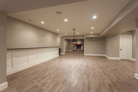 Basement game room with wainscoting and drink ledge open to stone fireplace in den in custom home by BCN Homes in Arlington, Virginia. Basement With Ledge Half Walls Decor, Wall With Ledge Basement, Drink Ledge Basement, Basement Wainscoting Ideas, Basement Wall Ledge, Basement With Ledge Half Walls, Basement Ledge Wall Ideas, Basement Half Wall Ledge Ideas, Basement Ledge