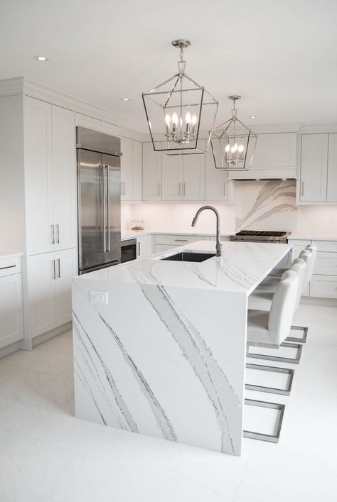 One of my favourite projects. This all white kitchen features Cambria Quartz Brittanicca countertops and a large island with waterfall edges. #brittanicca #whitekitchen #kitchendesign #waterfallisland #waterfalledge #whitekitchenideas #allwhitekitchen Kitchen Island Waterfall Edge, Waterfall Countertop Island, Quartz Waterfall Island, White Marble Kitchen Countertops, Townhome Design, Cambria Brittanicca, Waterfall Counter, Waterfall Island Kitchen, Waterfall Countertop