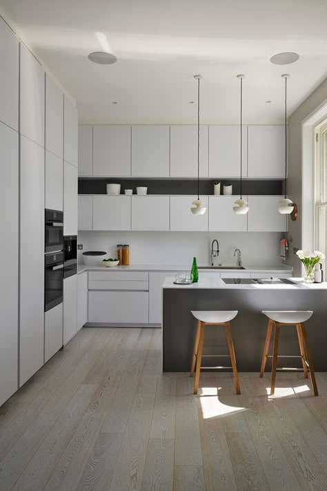 Handleless kitchen cabinets in this design by Connaught Kitchens run all the way to the ceiling offering lots of storage and making the most of the room’s scale. | #kitcheninspo #dreamkitchen #kitchendecor #storageideas #stoarge #kitchenstorage #kitchenisland #modernkitchen #luxurymodernkitchen #handlelesskitchen #kitchenflooring #kitchenflooringideas #kitchenvinylflooring #kbbmag Kitchen Cabinet Up To Ceiling, Tall Wall Kitchen Cabinets, Full Wall Kitchen Cabinets With Island, Kitchen Cabinet Height Ideas, Kitchen Wall To Wall Cabinets, Floor To Ceiling Kitchen Storage, Kitchen Cabinet High Ceiling, Kitchen With Full Height Cabinets, Kitchen To Ceiling Cabinets