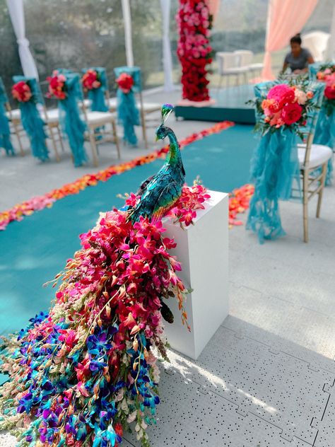 Mandaps at Indian weddings have always been the focal point for any wedding décor. Depending on the theme of the event, the colour for the flowers for the mandap is chosen. But what we spotted off late were these glorious multi-coloured floral mandaps that were the stuff of Pinterest dreams! These mandaps don’t follow any given colour palette and are usually a mix of colourful blooms that look so pretty. Colourful Sangeet Decor, Peacock Theme Wedding Indian, Peacock Haldi Decor, Peacock Sangeet Decor, Peacock Indian Wedding, Radha Krishna Wedding Decor, Mehendi Wedding Decor, Peacock Theme Wedding Decoration, Indian Wedding Colour Themes