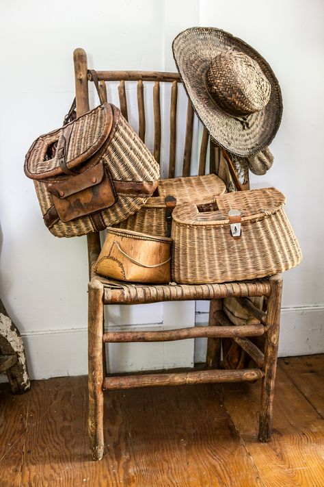 We're better at fishing for vintage creels (also known as fisher- men's baskets) than casting a line for what they were designed for. Piled onto an old twig chair, they're an easy spot to stash miscellaneous caps and scarves.   - CountryLiving.com Fishing Creel Decor Vintage, Fishing Basket Ideas, Victorian Scenery, Twig Chair, Vintage Fishing Decor, Fish Decoys, Door Hallway, New Kitchen Gadgets, Fishing Cabin