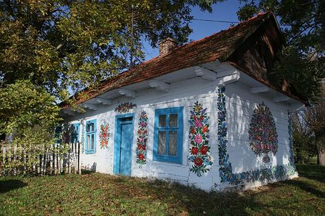 Charming Polish village where housewives paint every home in flowers to cover smoke stains from stoves * Each house in Zalipie, Poland, is decorated with its own floral motif * Women used whitewash to cover up the soot marks left above stoves * But marks still visible so they painted flowers on them, spreading outside * Now there's a competition every year to find the best flower painter Polish Folk Art, Glass Building, Ancient Village, Painted Cottage, Casa Exterior, Beautiful Villages, Garden Cottage, Krakow, House Painting