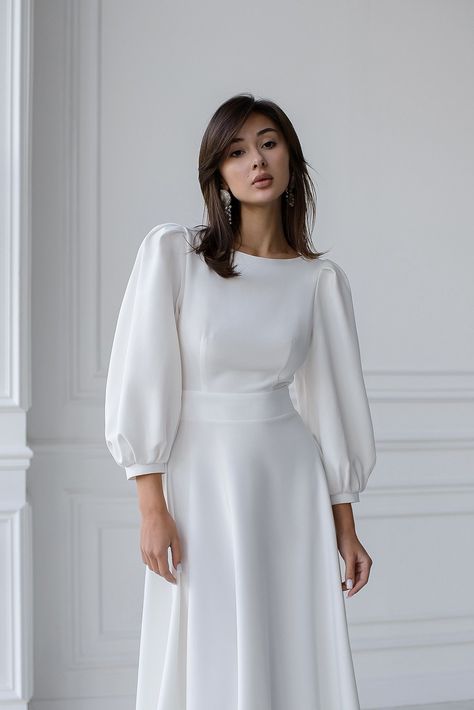 Captivate the room with the ELAGIA White Backless Puff Sleeve Midi Dress. The perfect fusion of sophistication and allure, featuring puff sleeves and a stunning backless design. #whitedress #backlessdress #puffsleeve #midi #ElagiaFashion #sophisticatedstyle #femininecharm #dressfashion #glamorouslook #etherealbeauty High Neck Puff Sleeve Dress, Puff Full Sleeve Dress, White Dress Puffy Sleeves, White Dress For Graduation, Puffy Sleeves Dress, Grad Outfits, White Dresses Graduation, Eid Dress, Nikah Dress