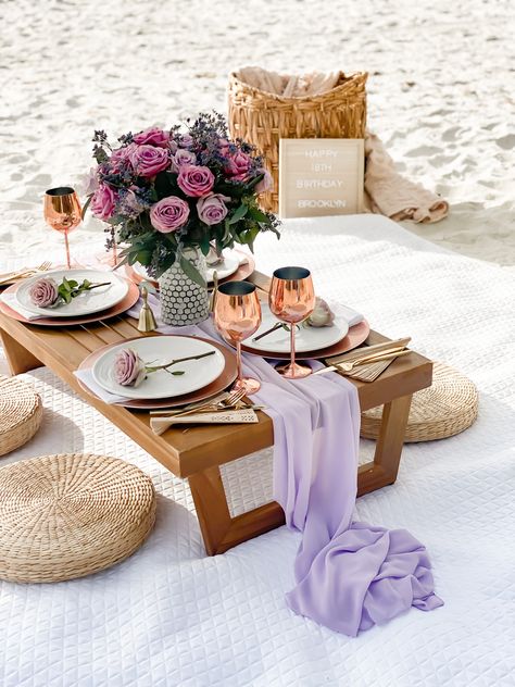 Purple lilac shades spread throughout the tablescape. 18th birthday on the beaches of Naples, FL. Specifically Wiggins Pass. Purple roses, rose gold chargers & wine cups. Shaded boho umbrellas with custom 18th birthday quote. Boho Beach Picnic Party, Beautiful Picnic Ideas, Small Birthday Celebration Ideas, Simple Beach Picnic, Diy Beach Picnic, Beach Picnic Ideas, Birthday On The Beach, Picnic Luxury, Beach Props