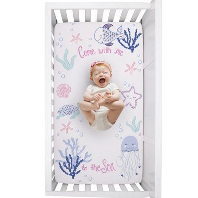 The Mermaid Lagoon Photo Op Nursery Fitted Crib Sheet frames your baby with fun undersea friends, sea turtles, coral, jellyfish, and starfish with a sweet message that says, "Come with me to the Sea". Featured in shades of pink, white, aqua, and blue; the border is an allover soft pink shell pattern. This 100% cotton crib sheet is fully elasticized for a safe and snug fit and measures 28" x 52" x 8". Fits a standard size crib/toddler mattress. Designed to create the perfect photo opportunity by Under The Sea Girl Nursery, Pink Under The Sea Nursery, Under The Sea Nursery Girly, Baby Girl Nursery Beach Theme, Mermaid Nursery Theme, Under The Sea Baby Girl Nursery Ocean Themes, Under The Sea Crib Bedding, Ocean Themed Nursery Cribs & Toddler Beds, Girly Nursery