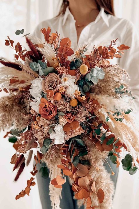 Elevate your bridal look with our enchanting cascading bridal boho bouquet, a captivating blend of bohemian charm and romantic allure. Delicately handcrafted with a curated selection of lush blooms, trailing vines, and soft foliage, this bouquet is designed to evoke a sense of free-spirited elegance. The cascading arrangement adds a touch of drama and movement, creating a breathtaking visual impact as you make your grand entrance. Fall Cascading Wedding Bouquets, Western Flower Arrangements, Western Wedding Bouquets, Terracota Wedding, Western Themed Wedding, Cascading Bouquet, Cascading Bridal Bouquets, Cascading Wedding Bouquets, Boho Wedding Bouquet