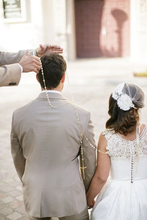 “As part of the ceremony to symbolize unity, a large loop of rosary beads is placed in a figure eight shape around the necks of the couple after they have exchanged their vows. The specially appointed ‘padrinos’ are in charge of lassoing the couple together. The lasso is then gifted to the bride as a souvenir of her taking the groom’s hand in marriage & symbolizes their commitment to each other.” Mexican Wedding Lasso, Lasso Ceremony, Mexican Wedding Traditions, Wedding Rosary, Wedding Lasso, Spanish Wedding, Unity Ceremony, Boda Mexicana, Wedding Week