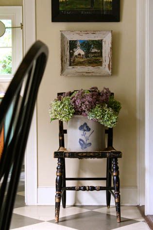 Flowers in a crock sitting on the seat of a chair under picture on a small wall Nora Murphy, Primitive Cottage, Countertop Decor, Farmhouse Decorating, English Decor, Old Chair, House Features, Primitive Decorating Country, Decorating Inspiration