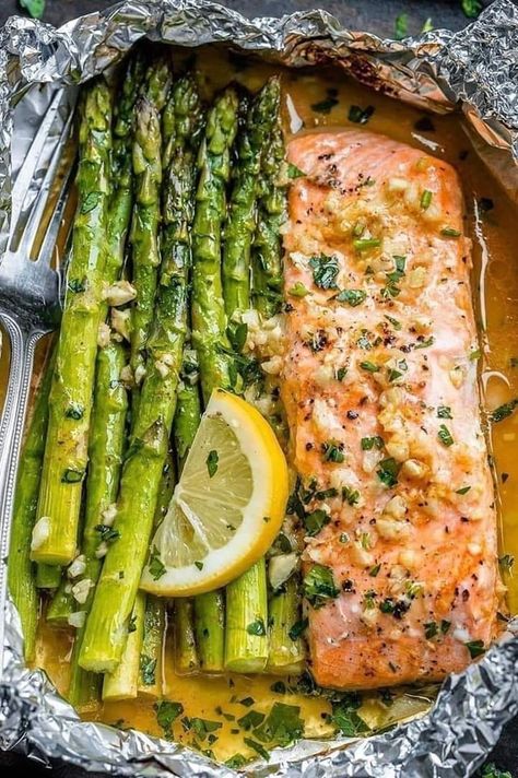 Baked salmon in foil with asparagus and lemon garlic butter sauce is a delicious and easy-to-make dish that's perfect for a healthy and flavorful meal. Here's Fish And Asparagus Foil Packets, One Sheet Salmon And Asparagus, Oven Baked Salmon And Asparagus, Salmon And Asparagus Baked In Foil, Salmon Recipes Foil Packets, Salmon In The Oven Recipes, Garlic Butter Salmon Recipes, How Long To Bake Salmon In Oven, Easy Salmon Recipes Baked Healthy