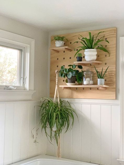 A DIY pegboard that can be used in any room in the house. Add shelves to hold plants, books, souvenierus or anything your heart desires. We created this for a wall in the bathroom, but it would be great in a kids room, a kitchen or above a desk.    We created this pegboard for a wall at the end of the tub in our all white bathroom. The bathroom needed some warmth and life and a plywood pegboard to hold plants was just the thing.    This can be made in any size using good quality plywo… Peg Board Tv Wall, Plywood Pegboard Wall, Peg Board Bathroom, Peg Board Shelves Diy, Boho Pegboard, Pegboard Plant Wall, Peg Board Plant Wall, Plywood Crafts Diy, Houseplants Bathroom