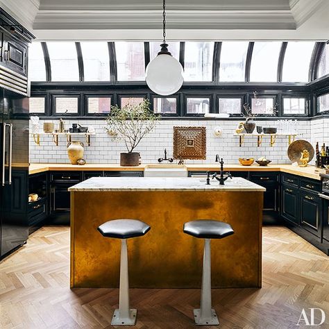 The kitchen is outfitted with cabinetry and butcher-block countertops by Fanuka; the island is clad in unlacquered brass and topped with Breccia Imperiale marble from Artistic Tile. The marble shelves rest on brackets from Liz’s Antique Hardware; the subway tile is from Home Depot, the painting of Saint Peter is an 18th-century work from Peru, and the barstools are vintage American. Nate Berkus Design, Celebrity Kitchens, Apartment Wishlist, Glamorous Kitchen, Conservatory Kitchen, Kitchen Apartment, Shelves Kitchen, Manhattan Apartment, New York City Apartment