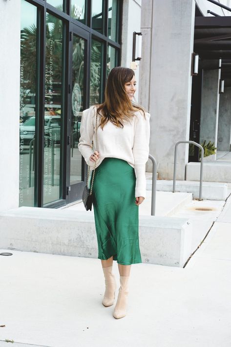 Emerald green midi skirt with cream sweater and sock boots Green Silk Dress With Sweater, Advent Outfit, Satin Green Dress Outfit, Christmas Outfit Green Skirt, Green Satin Skirt Outfit Winter, Silky Green Skirt Outfit, Emerald Green Skirt, Emerald Green Silk Skirt, Emerald Skirt