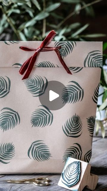 The English Stamp Company on Instagram: "Today’s reel is brought to you by Rachel who spent last week with us on work experience. We challenged her with wrapping an awkwardly shaped present and she absolutely smashed it! 🌟The gift is a bag full of delicious @niniorganics products, wrapped in blush sugar paper from @bcreativetolearn stamped with our 2” Tropical Fern in VersaFine Rain Forest green ink, held together with our easy peel double sided tape and tied up with our Havanne velvet ribbon #giftwrap #awkwardshapedgift #handstampedwrappingpaper #handmadegiftbag #handstampedgiftbag #mothersdayinspiration #mothersdaygift" Gift Wrapping With Double Sided Paper, How To Wrap A Backpack As A Gift, How To Make Gift Bags Out Of Gift Wrap, How To Wrap Awkward Shaped Gifts, How To Wrap A Purse As A Gift, Gift Bag From Wrapping Paper, Wrapping Paper Gift Bag, Awkward Gift Wrapping, Wrapping Paper Bag