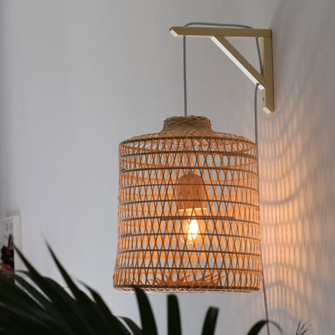 An eco-friendly plug-in wall lamp that is chock-full of character and cozy charm. Painstakingly woven into shape using bamboo strips, each shade is truly a handmade piece of art, marrying traditional craftsmanship with modern farmhouse aesthetics. https://lannapassa.com/product/wall-hanging-woven-bamboo-pendant-plug-in/ #walllamp #walllight #homedecor #pluginlight #pluginlamp #wallsconce #swaglight #bamboopendantlight #woodpendantlight #artisanhomedecor #artisancrafts #hanginglight #homed... Boho Lampshade, Fishing Traps, Plug In Wall Lamp, Hanging Rattan, Small Bathroom Sinks, Wooden Lampshade, Rattan Lamp, Lamp Pendant, Swag Light