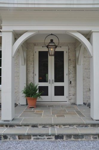 Beautiful wood bracing creates a design element in this entry. Bevolo French Quarter Lantern on yoke bracket with ladder rack. Front Door Lighting, Building A Porch, French Doors Exterior, Porch Columns, Porte Cochere, Traditional Exterior, House With Porch, Front Entrance, French Cottage