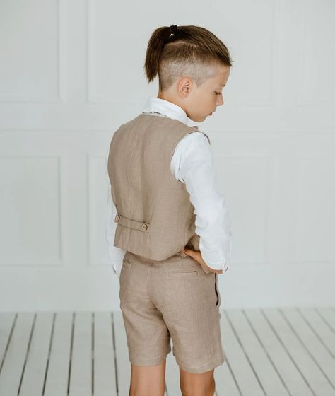 A linen vest and shorts set for boys is a great choice for weddings, offering both style and comfort. Here are some ideas to consider: 
1. Pastel Colors: Soft pastel shades like light blue, mint green, or blush pink add a touch of color while still keeping the outfit elegant and wedding-appropriate. 
2. Accessories: Complete the look with a matching bow tie or necktie, and consider adding suspenders for an extra cute and polished appearance. 
3. Comfort: Linen is breathable and comfortable, i... Linen Suit Wedding, Outfit With Vest, Wedding Outfit For Boys, Vest And Bow Tie, Linen Outfit, Outfit Elegant, Bearer Outfit, Linen Vest, White Linen Shirt