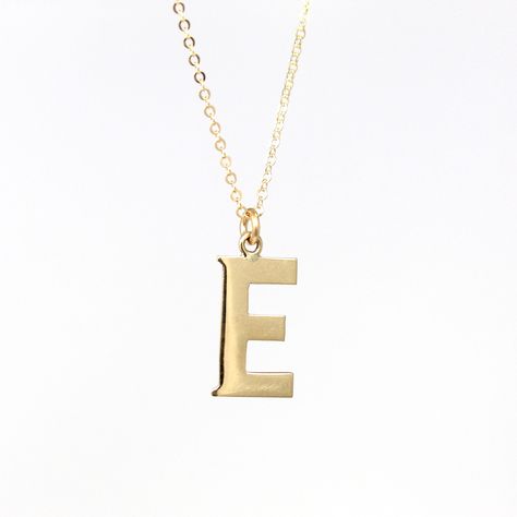 Unique modern circa 2000's era estate 10k yellow gold letter "E" necklace! This lovely charm is the shape of a capital letter "E". The single initial charm is shown modeled on a brand new 14k gold filled 20" chain. A fantastic piece of fine modern jewelry, perfect for anyone with a letter "E" name!  ERA - Circa 2000's - Modern METAL / MATERIAL - 10k yellow gold pendant, 14k gold filled chain MARKINGS / HISTORY - There are no markings, but this piece has been professionally tested.   CONDITION - Good condition. Yellow gold metal has been professionally polished & cleaned. Age appropriate patina & wear remains. Amazing letter "E" necklace!  SIZE / MEASUREMENTS - Chain Modeled: 20 inches, Pendant (including bail): 3/4 x 3/8 inches, Weight (without chain): .61 grams PRESENTATION: Listing inclu Letter E Necklace, 2000s Era, Gold Initial Pendant, Y2k Jewelry, Gold Letter, Initial Pendant Necklace, Letter E, Gold Initial, Necklace Size