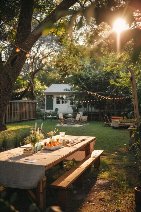 A sunlit backyard with a long wooden picnic table set for a meal, surrounded by string lights and trees, creating a cozy and inviting atmosphere. Adirondack Seating Area, Outdoor Bonfire Ideas Backyards, Backyard For Hosting, Cornhole Backyard Ideas, Picnic Table Backyard, Fun Backyard Party Ideas, Garden Bbq Ideas, Big Backyard Ideas, Hosting Aesthetic