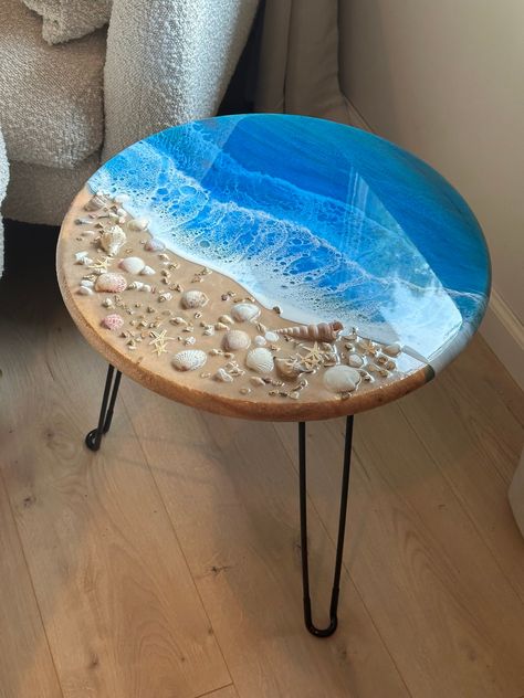 18 inch pine round with ocean resin detail and real seashells.  This table will come with three black prong legs and hardware for securing. Pilot holes will be predrilled under the table with instructions.  Customize your order by adding seashells or leaving plain.  Processing time is 2-3 weeks depending on pending orders, however, you may receive it earlier. Epoxy Resin Seashell Table, Beach Resin Table, Shell Table, Ocean Table, Resin Table Ideas, Resin Tables, Resin Ocean Art, Ocean Room Ideas, Diy Resin Table