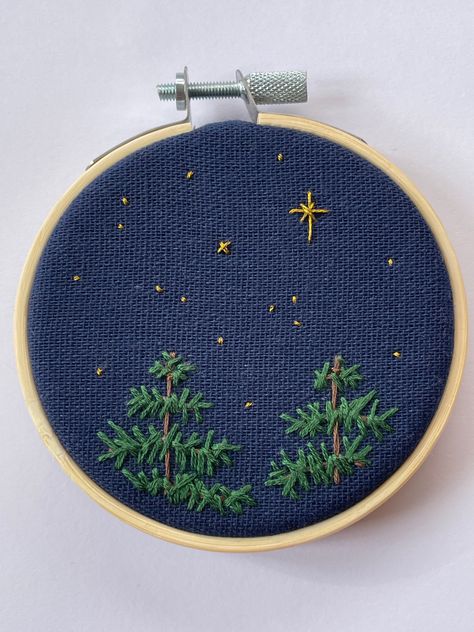 An embroidery hoop of the tops of pine trees against the night sky. Embroidered Night Sky, Pine Trees Embroidery, Embroidery Night Sky, Night Sky Embroidery, Pine Tree Embroidery, Earth Embroidery, Celestial Embroidery, Sky Embroidery, Embroidered Beanies