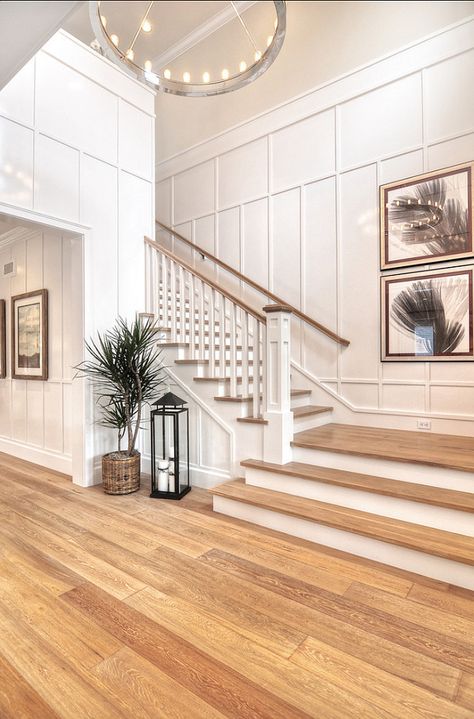 Detailed finish carpentry consists of wainscoting along the walls as well as floor boards and crown molding in this entryway. Vstupná Hala, White Staircase, Diy Staircase, Staircase Remodel, Staircase Decor, Casa Country, Transitional Bedroom, Foyer Decorating, House Stairs