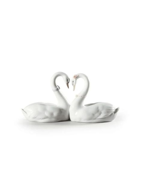 Height (in) 5.118 Width (in) 10.63 Length (in) 3.937 Porcelain Type Gloss Sculptor José Puche Figurine of two swans with their necks joined together forming a glossy white porcelain heart decorated with flowers and blue ribbon. Of all the symbols of love, few are as elegant as these two swans that form a heart with their long necks as they gaze lovingly at each other. The perfect piece to declare a feeling, to mark a special moment and to keep it alive forever. Love Swans, Two Swans, Swan Wedding, Symbols Of Love, Porcelain Heart, Swan Decor, Black Makeup Bag, Swan Figurine, Lladro Figurines